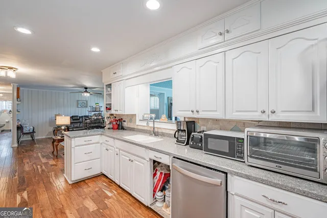 a kitchen with granite countertop a sink and cabinets