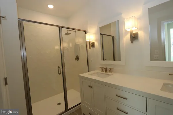 a bathroom with a shower sink and mirror