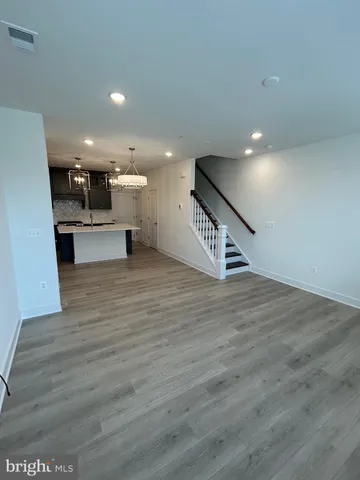 a view of a living room and kitchen with furniture and wooden floor