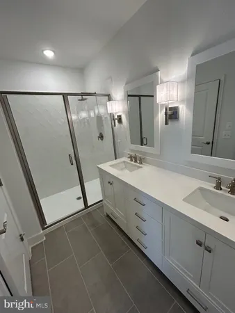 a bathroom with a double vanity sink mirror and shower