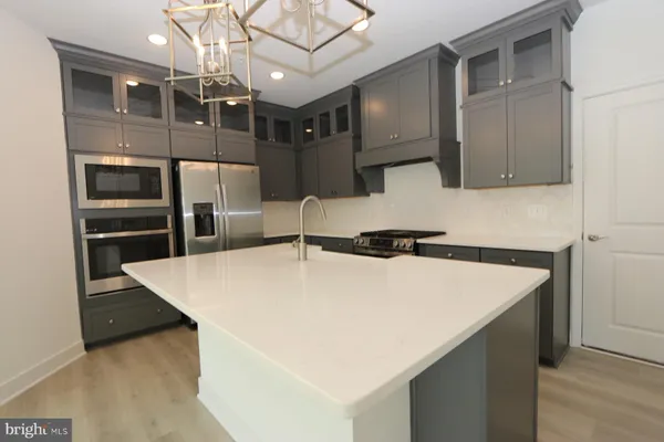 a large kitchen with a stove a refrigerator and a sink