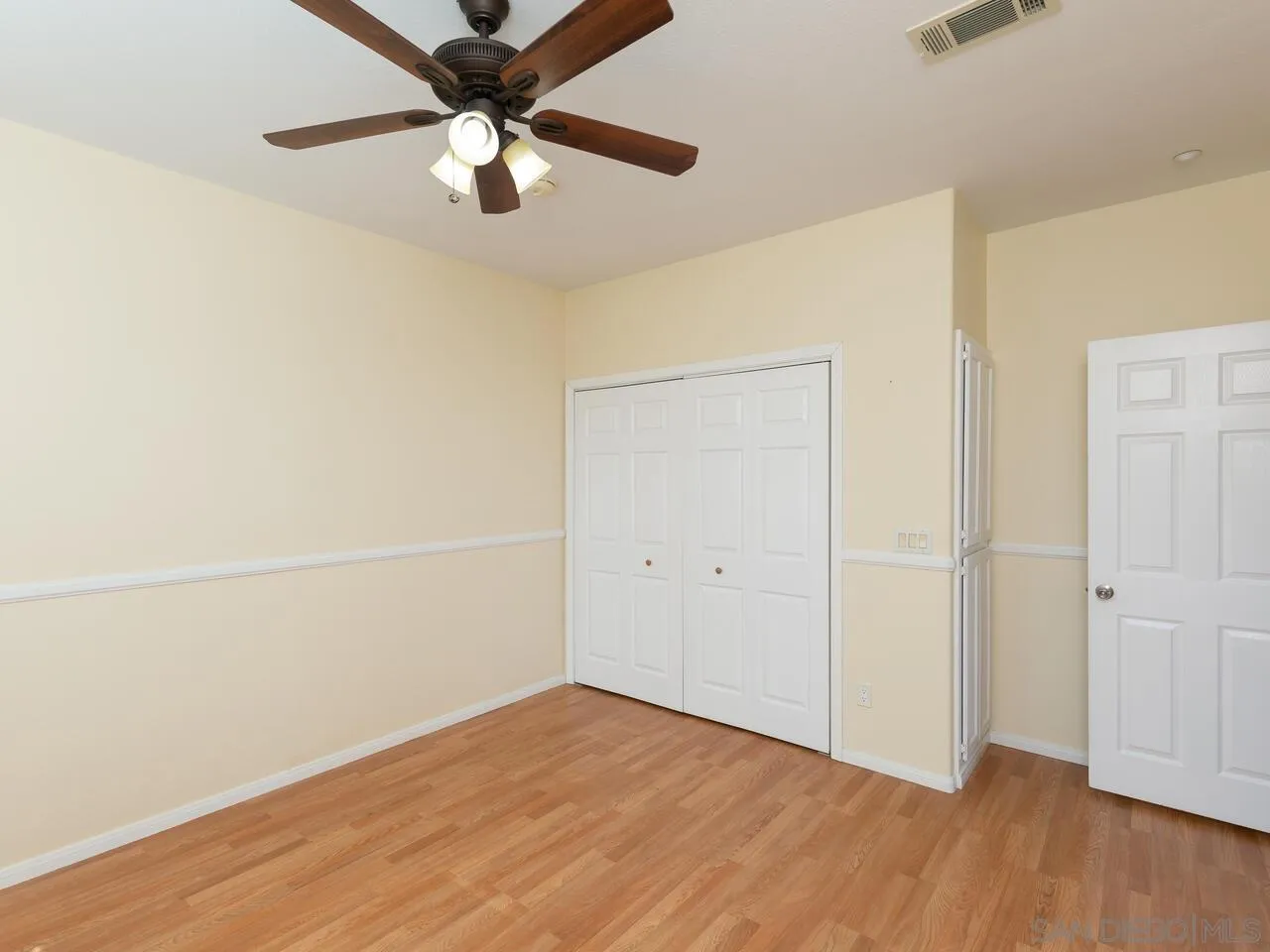 1732 Tavern Road Alpine, CA 91901 - Photo 22 of 60 an empty room with wooden floor a ceiling fan and a ceiling fan