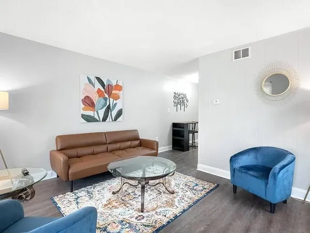 a living room with furniture and wooden floor