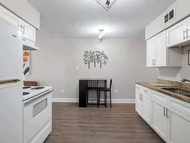 a kitchen with a stove cabinets and a wooden floor