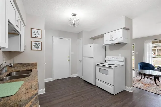 a kitchen with a stove a sink and a refrigerator