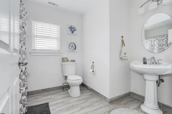 a bathroom with a sink toilet and a mirror