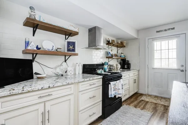a kitchen with granite countertop a sink stove and cabinets