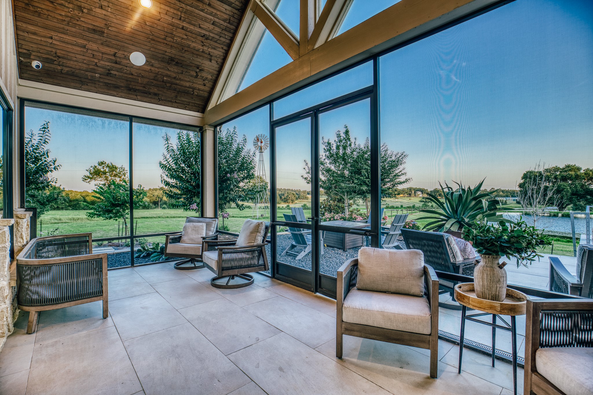 1034 Hilbun Road New Ulm, TX 78950 - Photo 16 of 49 Enjoy year-round outdoor living from the screened porch off the primary suite, complete with fireplace, vaulted wood ceiling, and panoramic views of the pond, pool, and rolling countryside beyond.