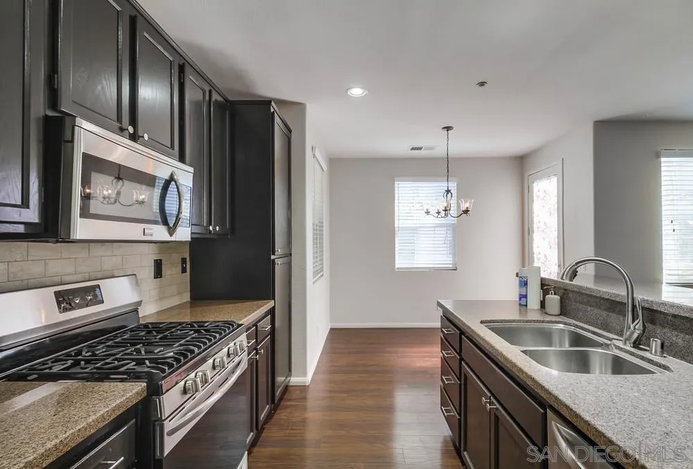 1298 Fools Gold Way, Unit 4 Chula Vista, CA 91913 - Photo 15 of 38 a kitchen with stainless steel appliances granite countertop a sink stove and refrigerator