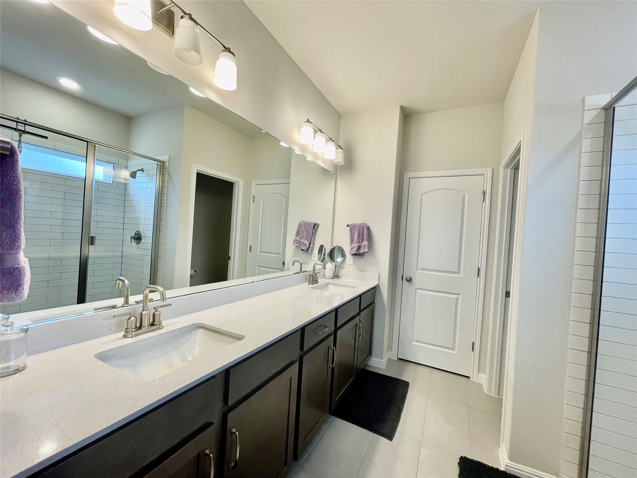 232 Denali Way Dripping Springs, TX 78620 - Photo 20 of 35 Full bath with a shower stall, double vanity, and light tile patterned floors