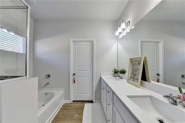 a bathroom with a tub sink and mirror