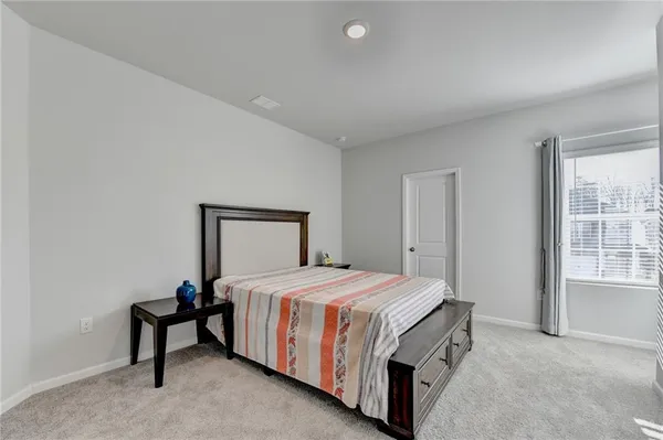 a bedroom with a bed a table and painting