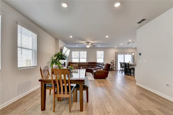 a view of dining room and livingroom with furniture wooden floor a rug a potted plant and a chandelier