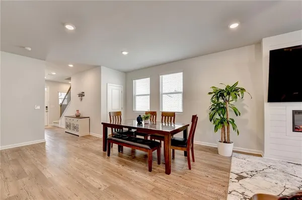 a living room with furniture a potted plant and a large window