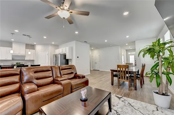 a living room with furniture kitchen and a potted plant