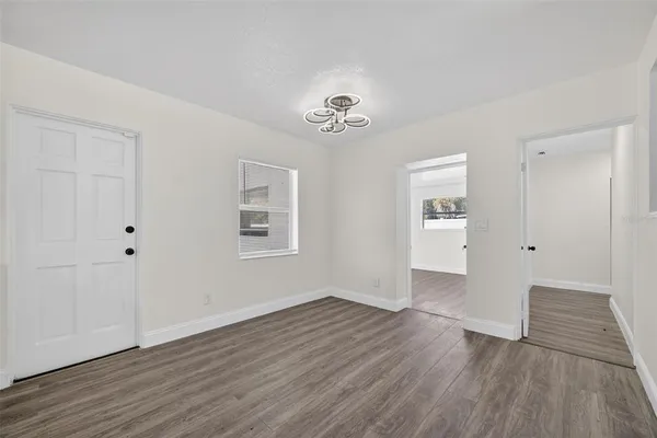 a view of a big room with wooden floor and windows
