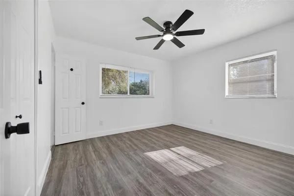 a view of a house with a yard and a large tree