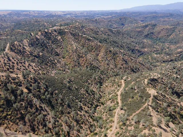 an aerial view of house with yard and mountain view in back