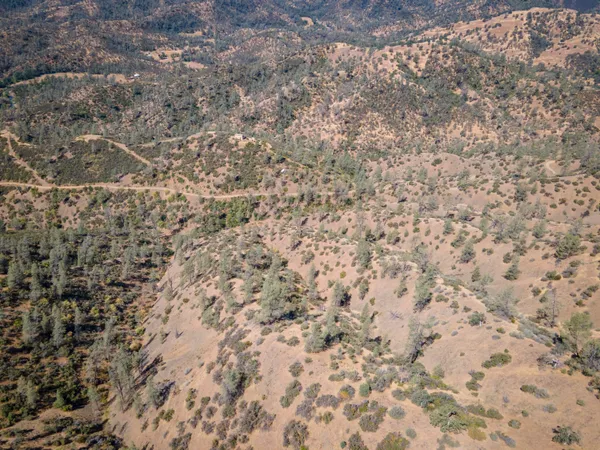 a view of a dry yard with mountains in the background