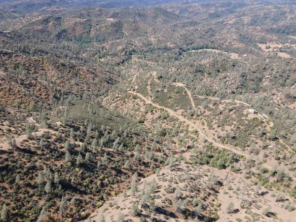 a view of a dry yard with mountains in the background