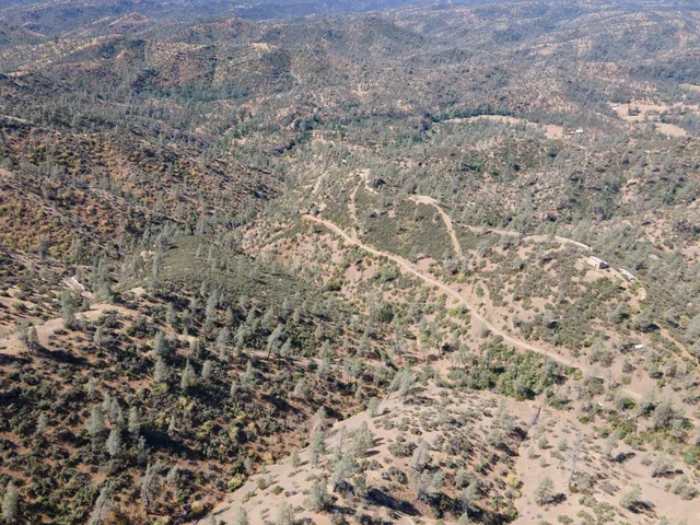 a view of a dry yard with mountains in the background