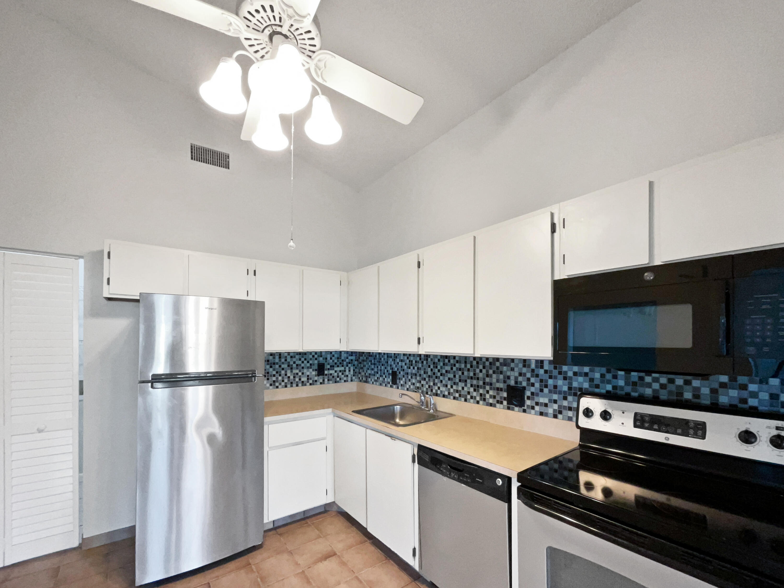 4249 Willow Pond Circle West Palm Beach, FL 33417 - Photo 29 of 30 a kitchen with stainless steel appliances granite countertop a refrigerator and a stove top oven