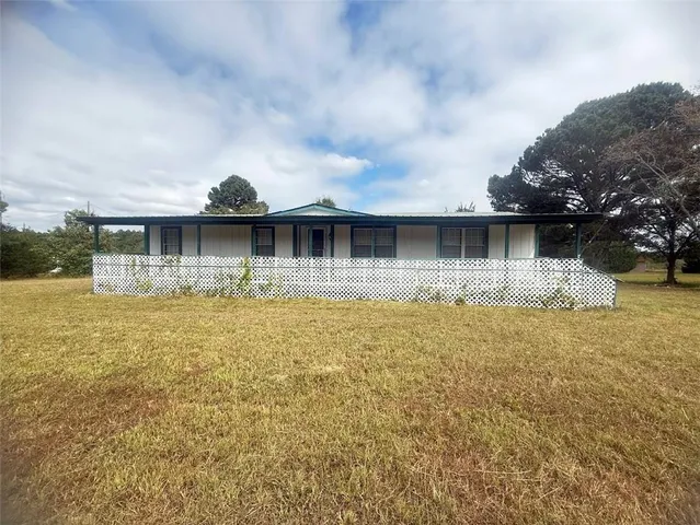 a view of a house next to a lake with a big yard
