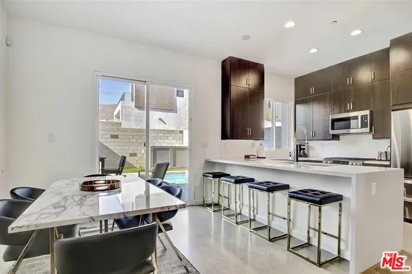 a kitchen with stainless steel appliances kitchen island granite countertop a sink and cabinets