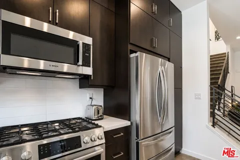 a kitchen with a sink a counter and a view of living room