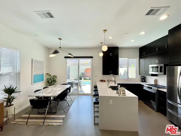 a living room with kitchen island furniture and a flat screen tv