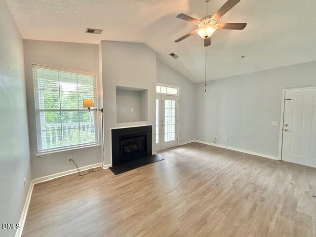 a view of an empty room with a fireplace and a window