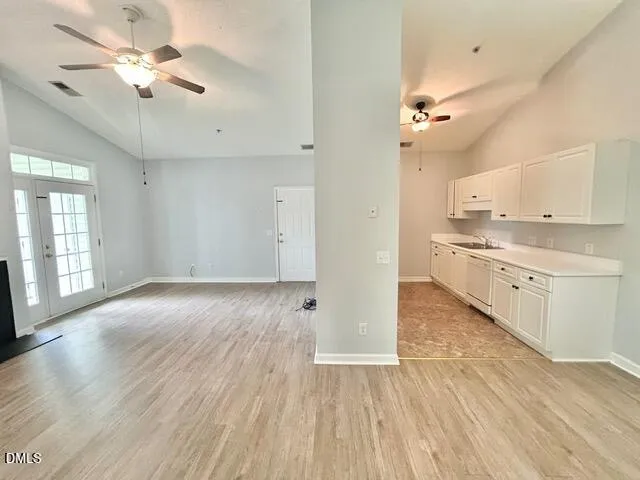 wooden floor in an empty room with a kitchen