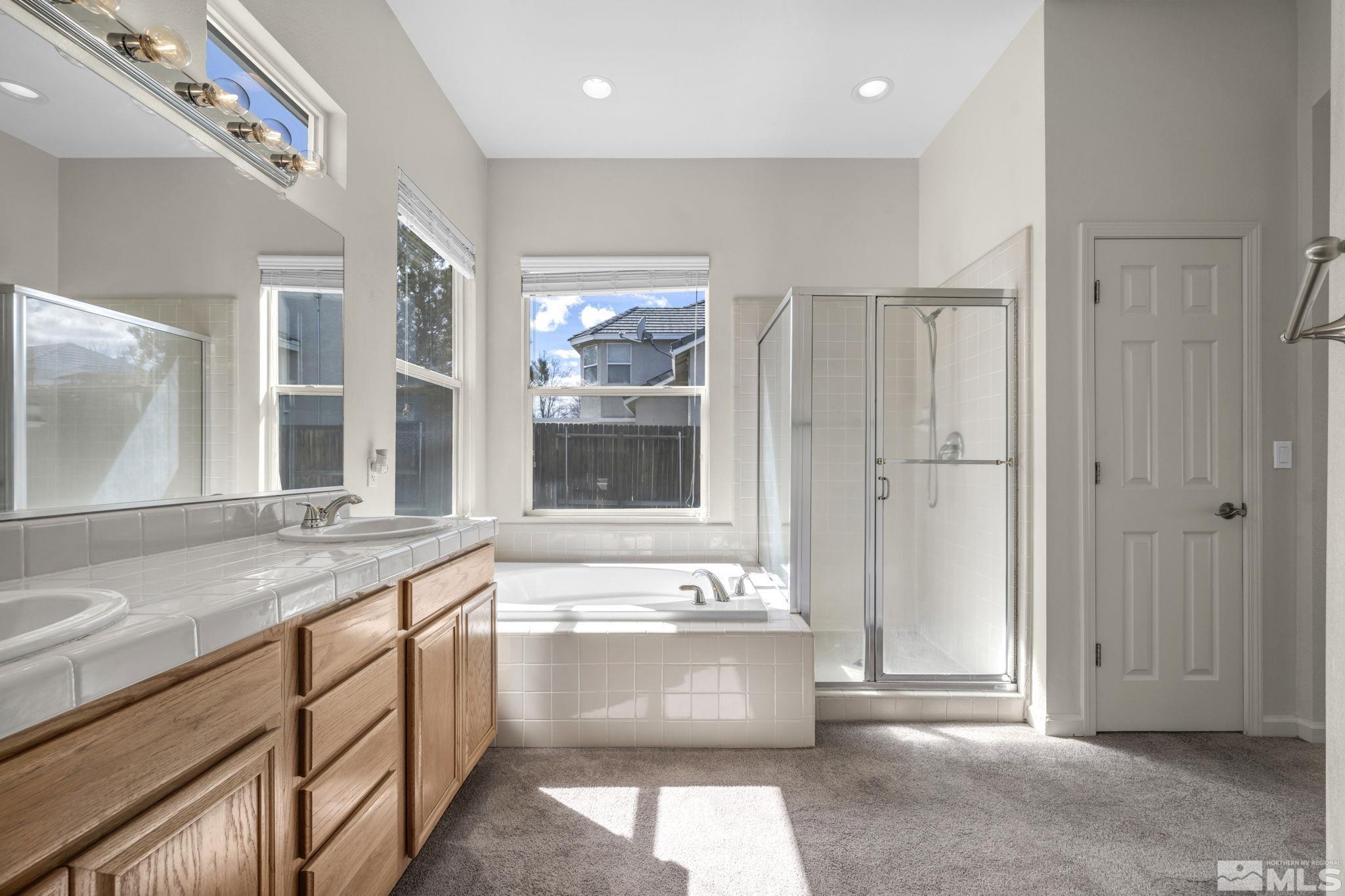 9705 Rolling Rock Court Reno, NV 89521 - Photo 15 of 19 a bathroom with a tub a sink and mirror