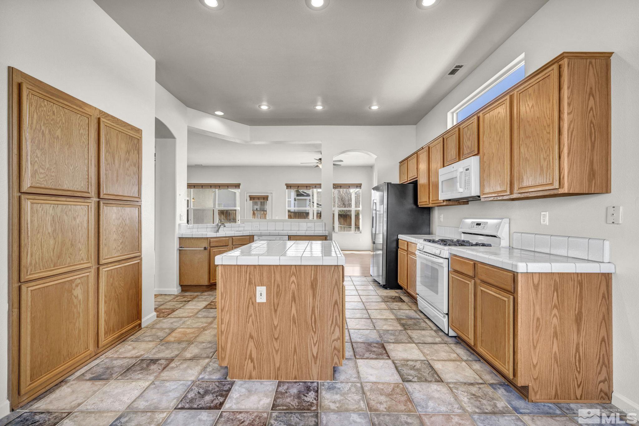 9705 Rolling Rock Court Reno, NV 89521 - Photo 6 of 19 a large kitchen with stainless steel appliances granite countertop a refrigerator a stove top oven and a sink