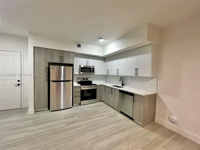 a kitchen with stainless steel appliances granite countertop a refrigerator and a sink