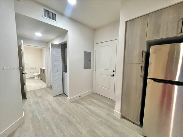 a view of a refrigerator in kitchen and wooden floor