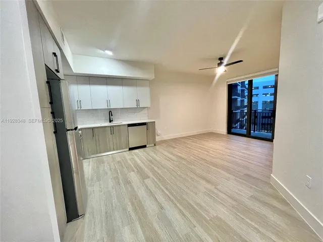 a view of empty room with wooden floor and window