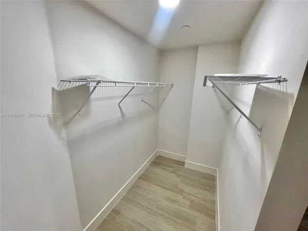 a view of walk in closet with empty racks