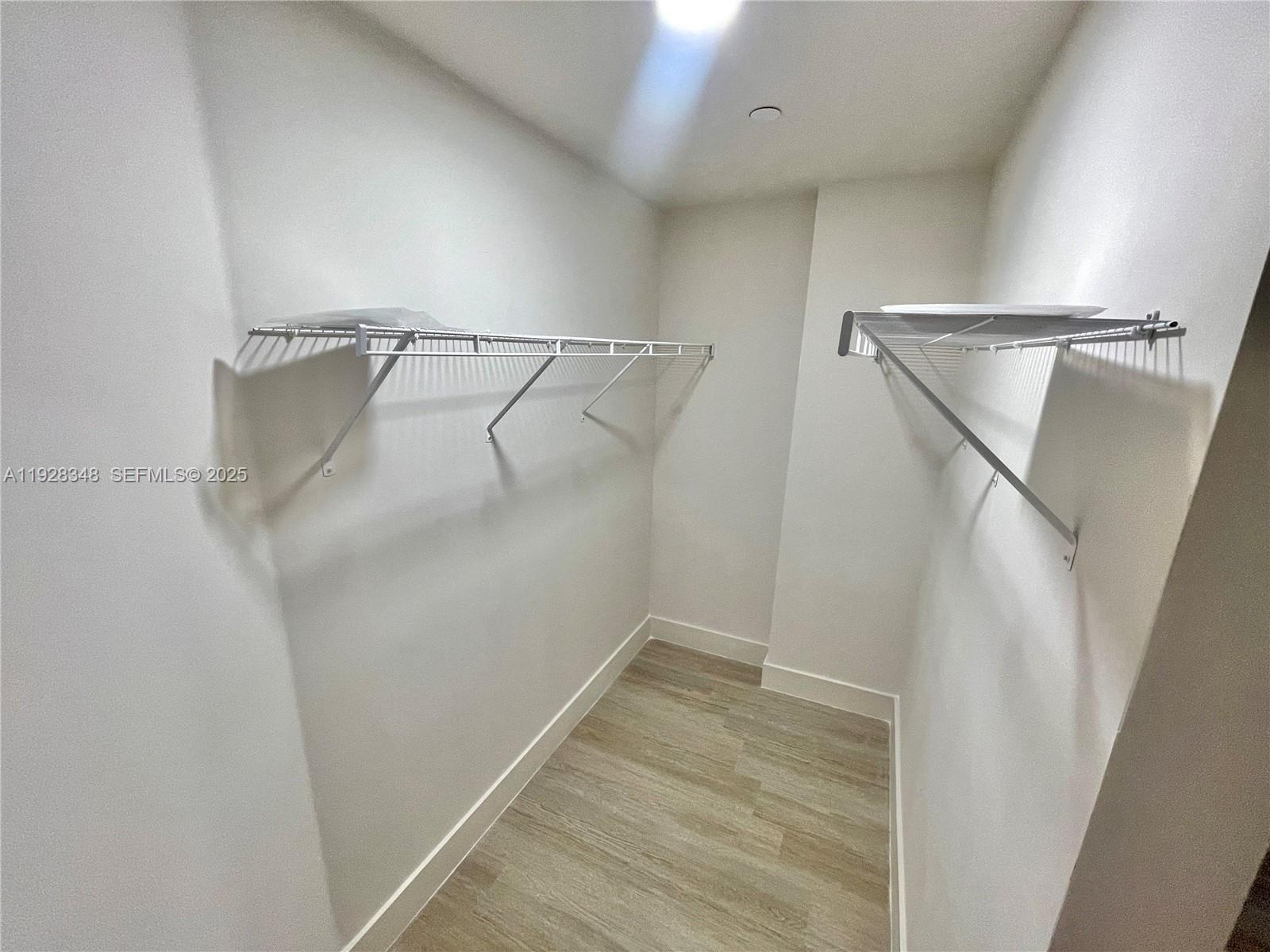 18412 Homestead Avenue, Unit 124 Miami, FL 33157 - Photo 7 of 20 a view of walk in closet with empty racks
