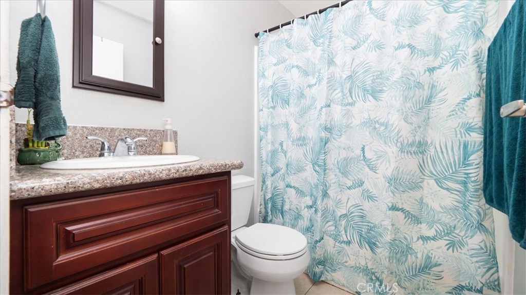 4440 Daniel Drive Riverside, CA 92503 - Photo 16 of 20 a bathroom with a granite countertop sink and a toilet