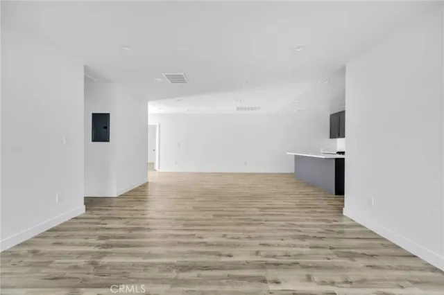 an empty room with wooden floor and sliding door