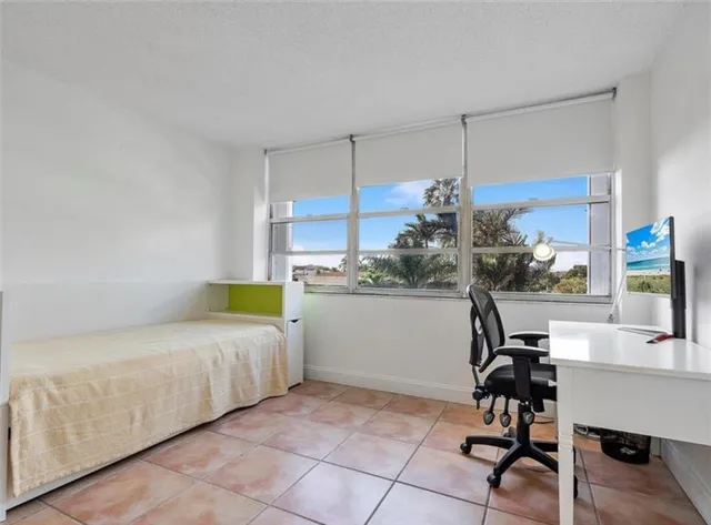 a bedroom with a bed a desk and chair