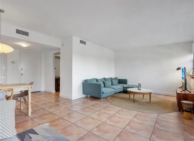a living room with furniture and a dining table with chairs