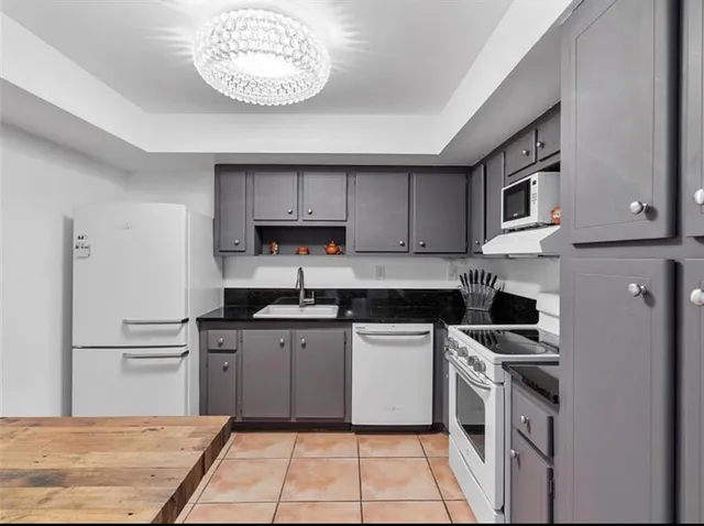 a kitchen with stainless steel appliances granite countertop a stove a sink dishwasher and a refrigerator