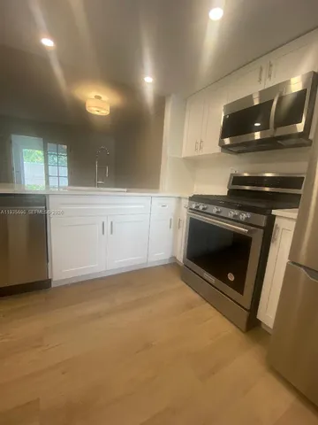 a kitchen with a stove and white cabinets