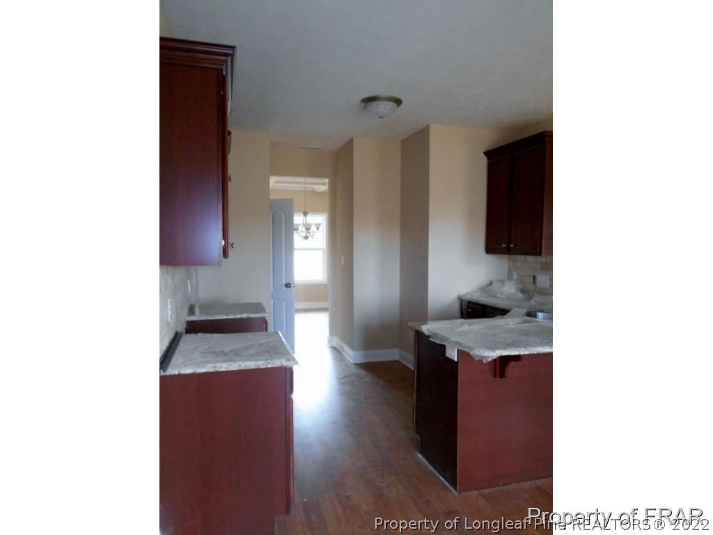 3463 Thrower Road Hope Mills, NC 28348 - Photo 5 of 24 a kitchen with granite countertop a sink and a stove top oven