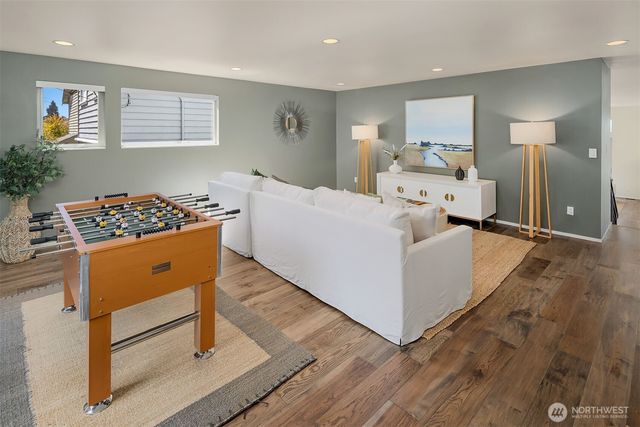 a living room with furniture and a dresser with wooden floor