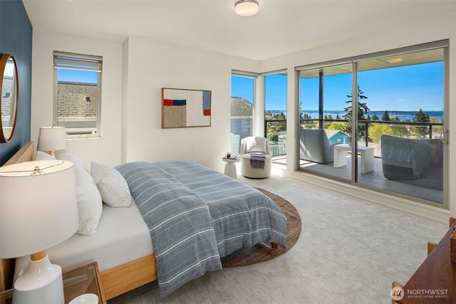 a bedroom with a bed and large windows