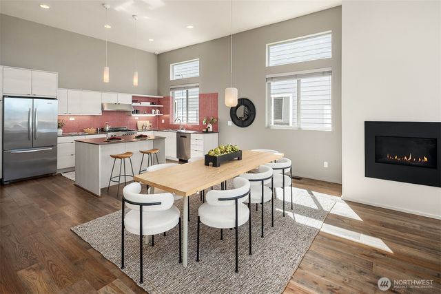 a kitchen with a dining table chairs and refrigerator