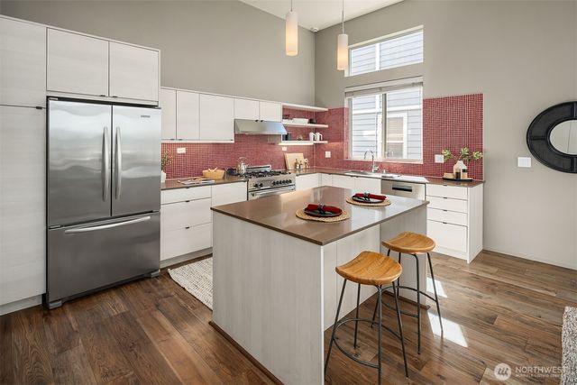 a kitchen with a refrigerator a stove a sink and a stove with wooden floor